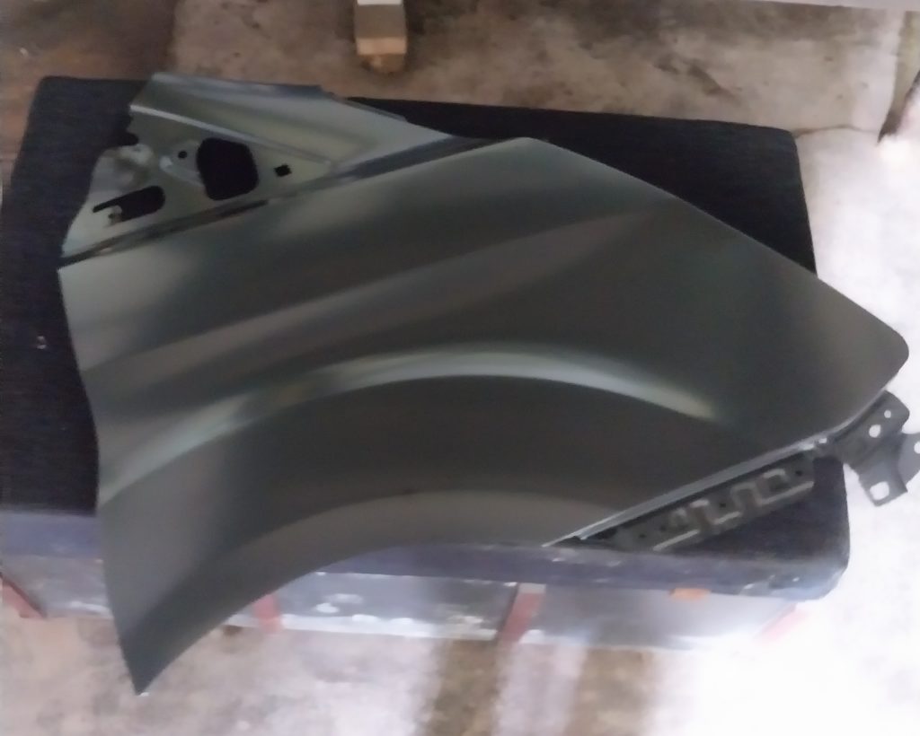 A new wing panel ready coated in black primer.