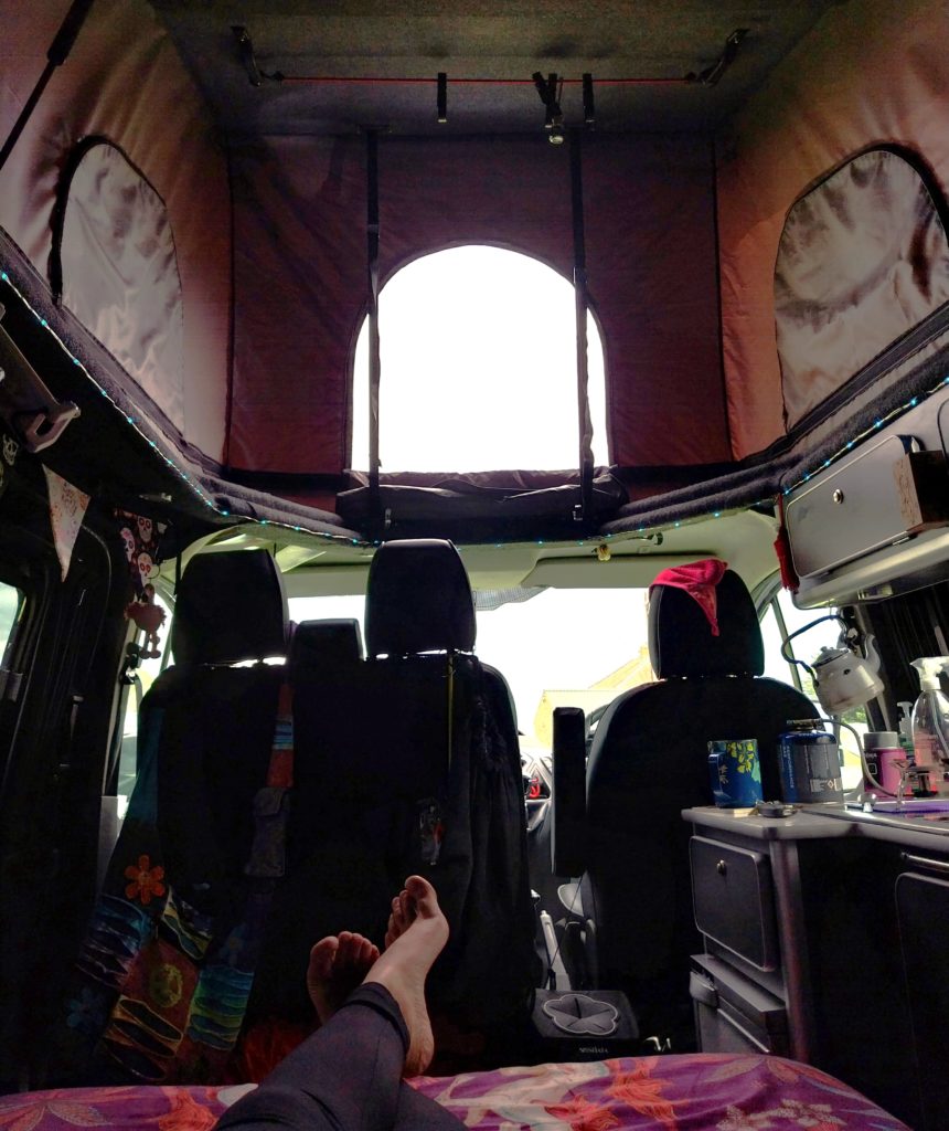 The inside of a pop-top campervan with ample headroom.